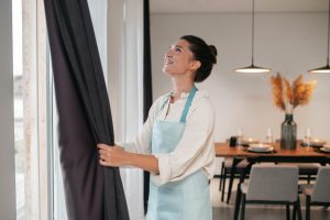 A girl folding her custom curtains UK online