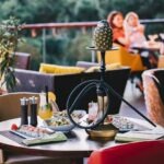 side view served table with sushi and pineapple shisha