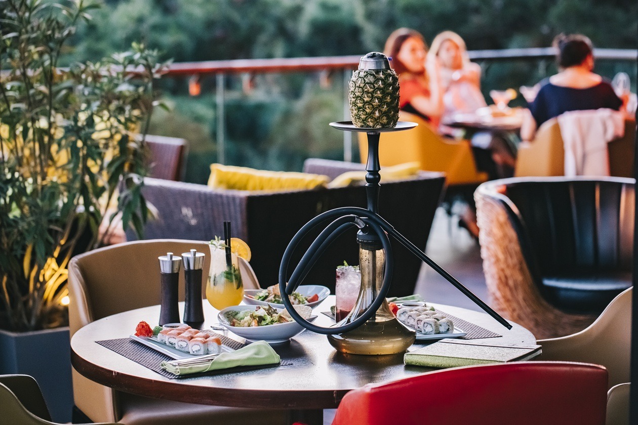 side view served table with sushi and pineapple shisha