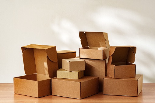 Stacked Cardboard Boxes On Wooden Surface In Sunlight close up